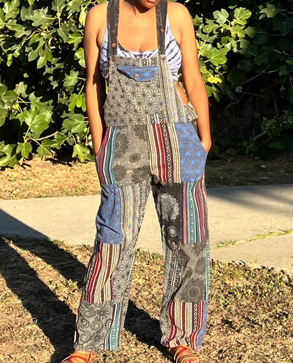 Model wearing handmade patchwork cotton overalls with wide legs and multi-color fabric panels, outdoors in natural light.