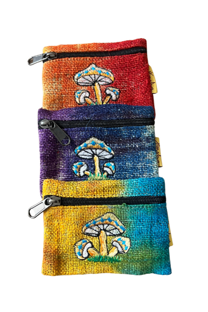 Three colorful handmade mushroom zip pouches made from hemp and cotton, featuring tie-dye patterns and embroidered mushroom artwork.