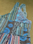 Flat lay back view close-up of pocket and patchwork details on blue patchwork overalls