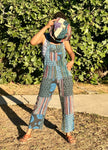 Front view of handmade blue patchwork cotton overalls worn outdoors styled with hat