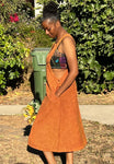 Side view of burnt orange cotton overall dress showing relaxed fit