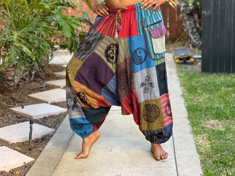 Model bending knee to show loose fit and bagginess of patchwork harem pants
