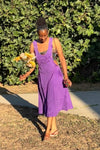 Model walking outdoors wearing purple cotton overall dress