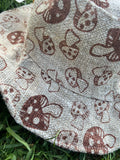 mushroom bucket hat side details on grass background