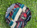 Light patchwork bucket hat with frayed edges angled view on grass